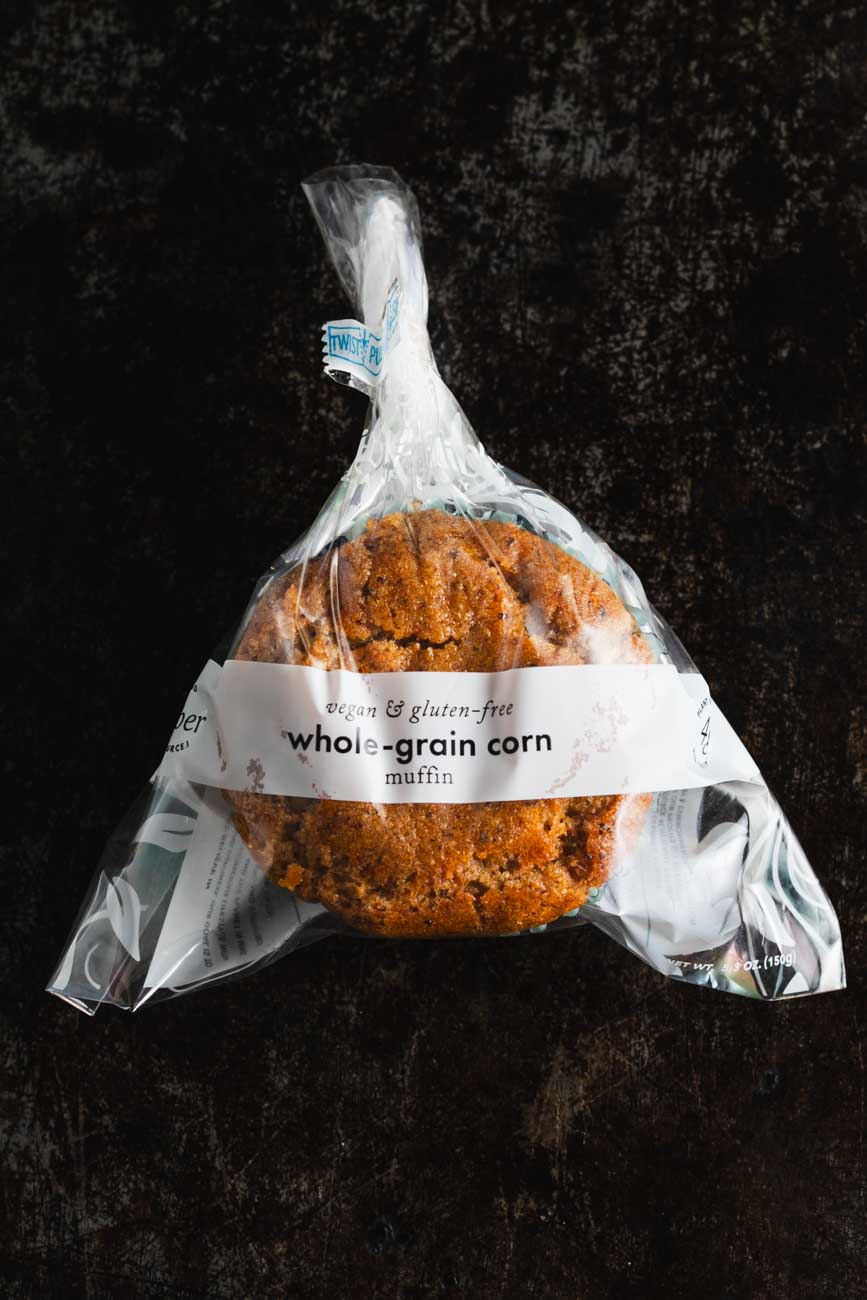 A whole-grain corn muffin packaged in a clear packaging.