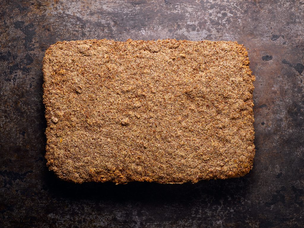 Breakfast protein bar slab on a dark textured background.