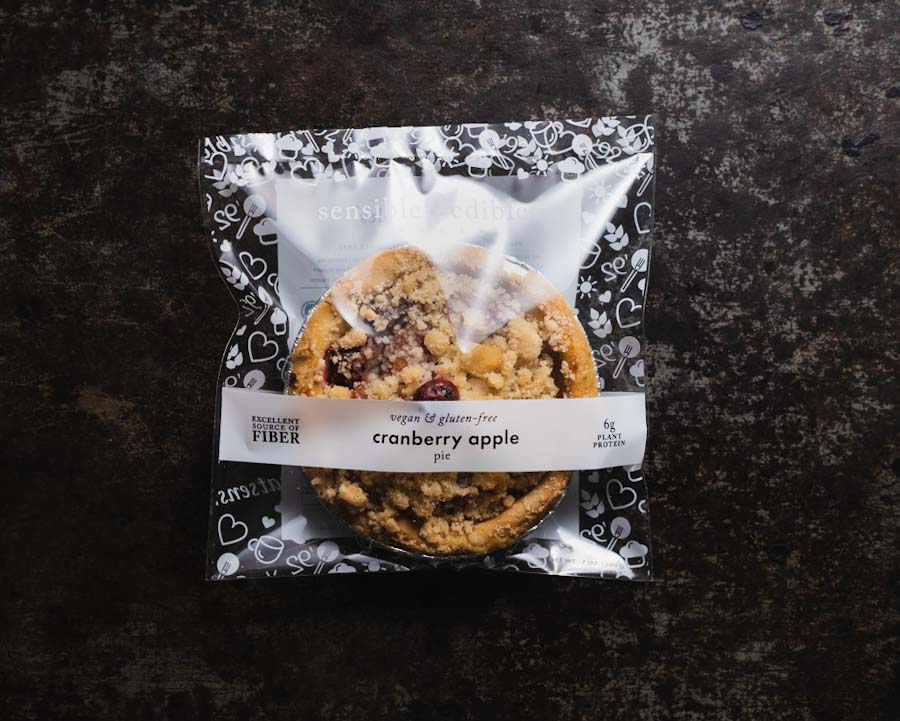 Packaged mini cranberry apple pie from Sensible Edibles Bakery, labeled and wrapped in decorative packaging.